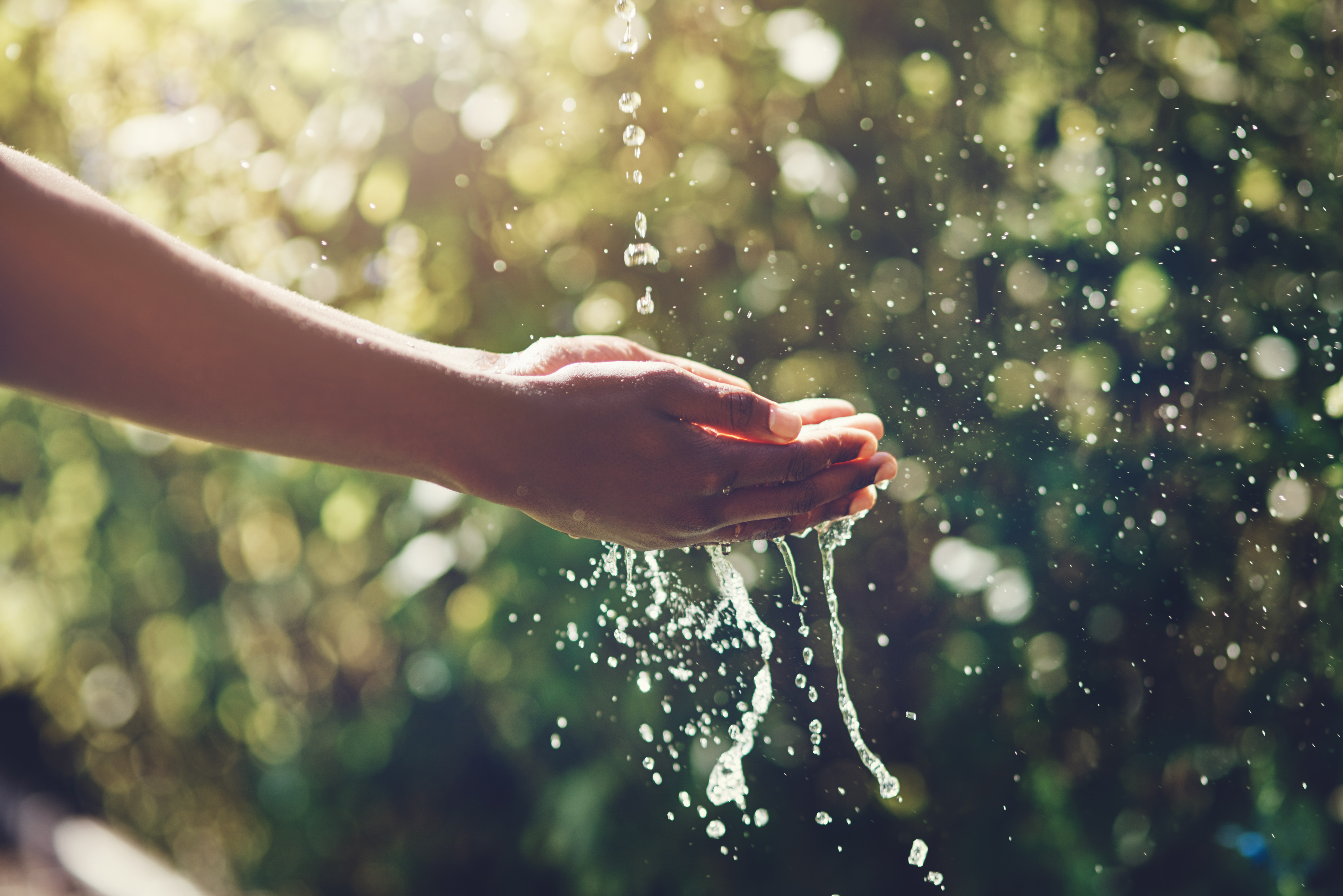 manos de mujer lavandose con agua en el exterior